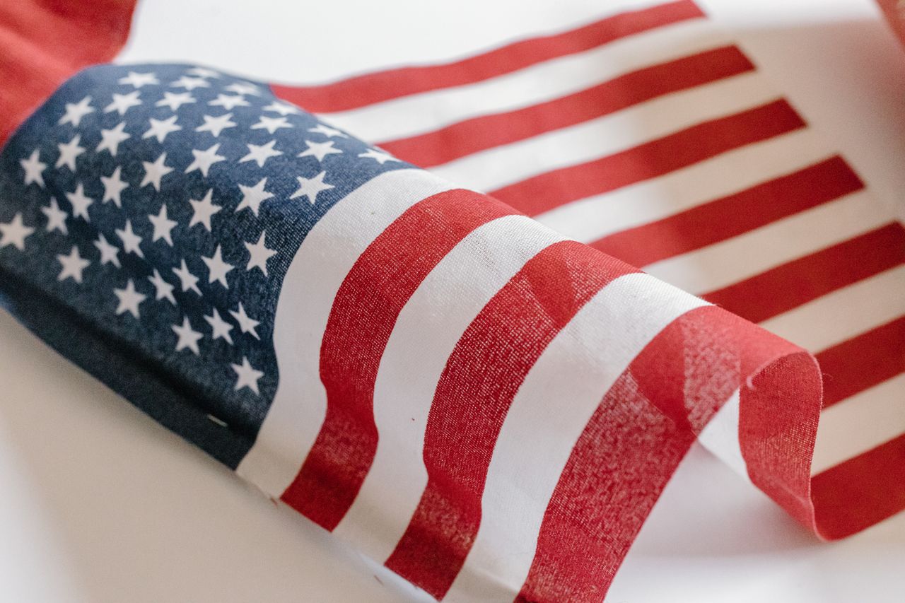 A detailed close-up of the American flag fabric showing stars and stripes in soft natural light.